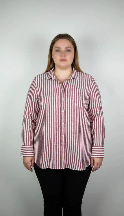 شومیز زنانه استوک سایز بزرگ با طرح راهراه صورتی، آستین بلند و تنخور راحت، مناسب سایز ۴۸–۵۰، ایستاده روی مانکن با فرم آزاد.