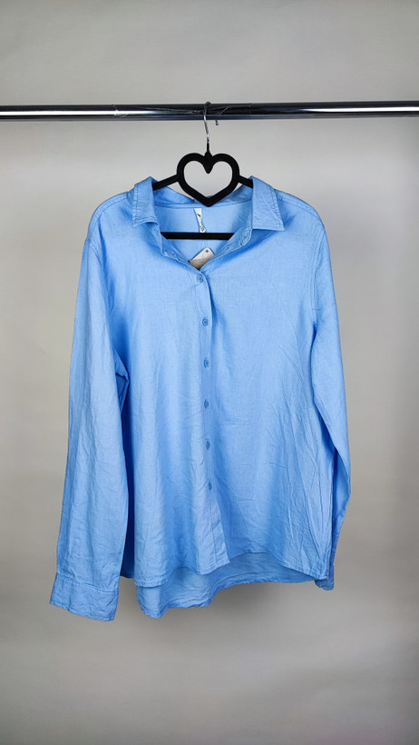 شومیز زنانه استوک آبی روشن با یقه ساده و آستین بلند، تنخور مرتب و راحت روی مانکن، مناسب سایز ۴۲–۴۴.