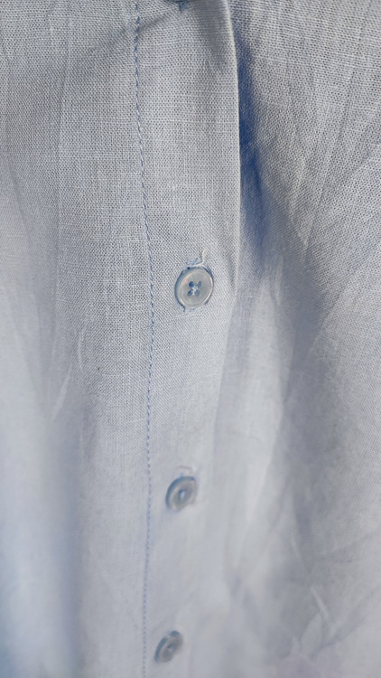 شومیز زنانه استوک آبی روشن با یقه ساده و آستین بلند، تنخور مرتب و راحت روی مانکن، مناسب سایز ۴۲–۴۴.