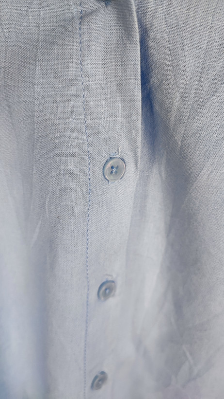 شومیز زنانه استوک آبی روشن با یقه ساده و آستین بلند، تنخور مرتب و راحت روی مانکن، مناسب سایز ۴۲–۴۴.