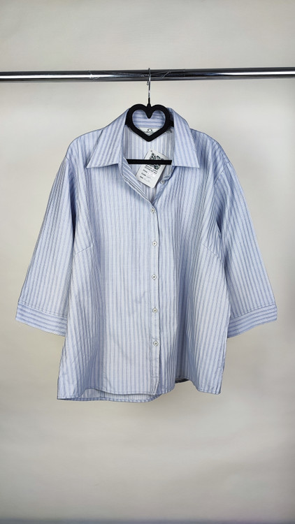 شومیز زنانه استوک آبی روشن با یقه باز و آستین نیمهبلند، تنخور آزاد و راحت روی مانکن، مناسب سایز ۴۸–۵۰.