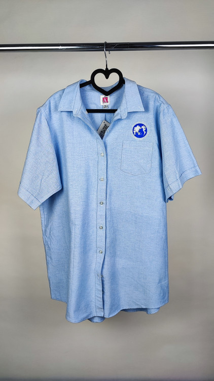 شومیز زنانه سایز بزرگ استوک آبی روشن با یقه ساده و آستین کوتاه، تنخور آزاد و خوشفرم روی مانکن، مناسب سایز ۴۶–۴۸.