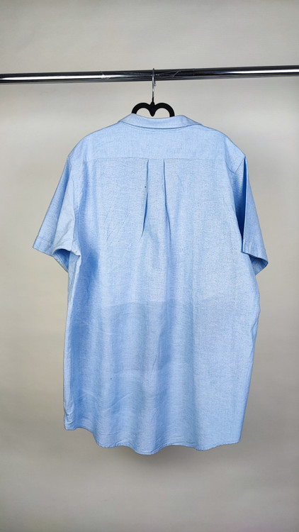 شومیز زنانه سایز بزرگ استوک آبی روشن با یقه ساده و آستین کوتاه، تنخور آزاد و خوشفرم روی مانکن، مناسب سایز ۴۶–۴۸.