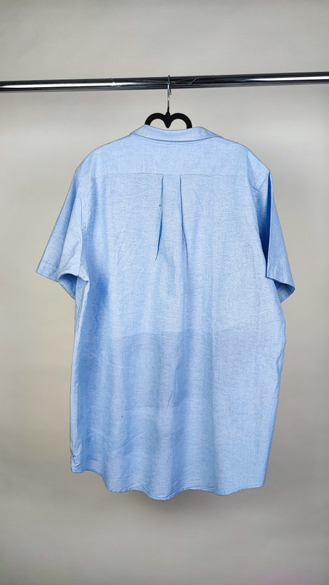 شومیز زنانه سایز بزرگ استوک آبی روشن با یقه ساده و آستین کوتاه، تنخور آزاد و خوشفرم روی مانکن، مناسب سایز ۴۶–۴۸.