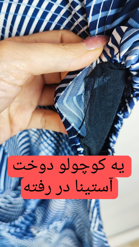 پیراهن زنانه استوک آبی طرحدار، آستین کوتاه، یقه ساده، قد بالای زانو، فرم مرتب و راحت، مناسب استایل روزمره، ایستاده روی مدل با پسزمینه روشن.