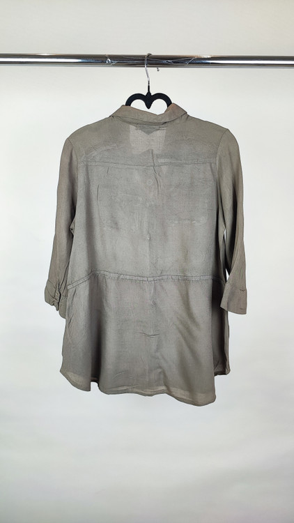 شومیز زنانه استوک رنگ خنثی، آستینسهربع، یقه ساده، فرم راحت و مرتب، مناسب استایل روزمره، ایستاده روی مدل با پسزمینه روشن.