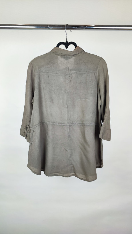 شومیز زنانه استوک رنگ خنثی، آستینسهربع، یقه ساده، فرم راحت و مرتب، مناسب استایل روزمره، ایستاده روی مدل با پسزمینه روشن.