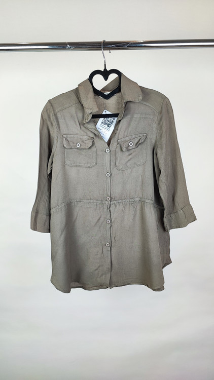 شومیز زنانه استوک رنگ خنثی، آستینسهربع، یقه ساده، فرم راحت و مرتب، مناسب استایل روزمره، ایستاده روی مدل با پسزمینه روشن.