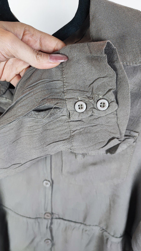 شومیز زنانه استوک رنگ خنثی، آستینسهربع، یقه ساده، فرم راحت و مرتب، مناسب استایل روزمره، ایستاده روی مدل با پسزمینه روشن.