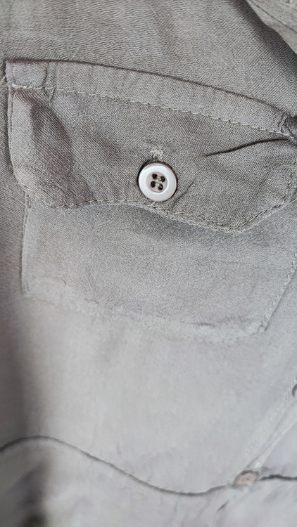 شومیز زنانه استوک رنگ خنثی، آستینسهربع، یقه ساده، فرم راحت و مرتب، مناسب استایل روزمره، ایستاده روی مدل با پسزمینه روشن.