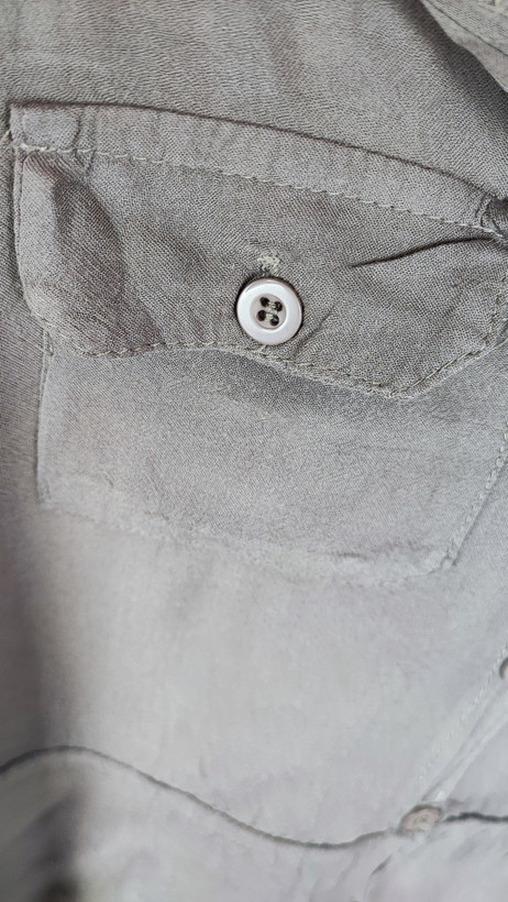 شومیز زنانه استوک رنگ خنثی، آستینسهربع، یقه ساده، فرم راحت و مرتب، مناسب استایل روزمره، ایستاده روی مدل با پسزمینه روشن.