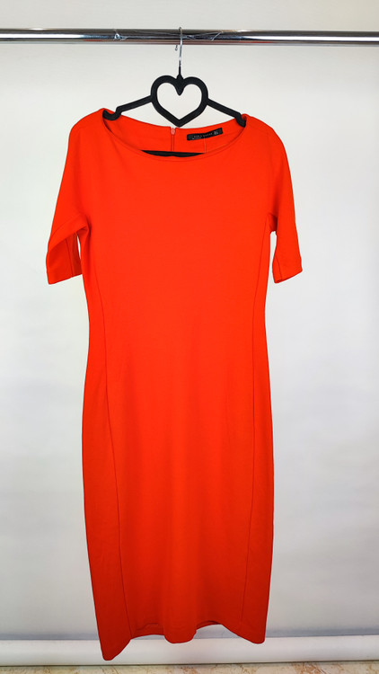 پیراهن زنانه استوک قرمز، آستین کوتاه با یقه باز، فرم ساده و جذب، قد میدی بلند، مناسب استایل رسمی و نیمهمجلس، ایستاده روی مدل با پسزمینه روشن.