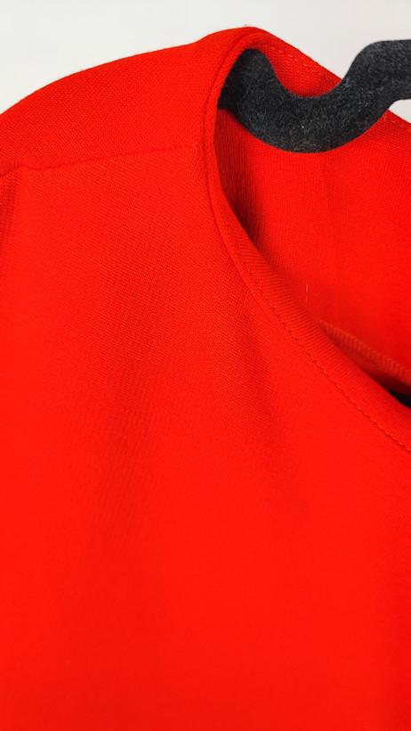 پیراهن زنانه استوک قرمز، آستین کوتاه با یقه باز، فرم ساده و جذب، قد میدی بلند، مناسب استایل رسمی و نیمهمجلس، ایستاده روی مدل با پسزمینه روشن.