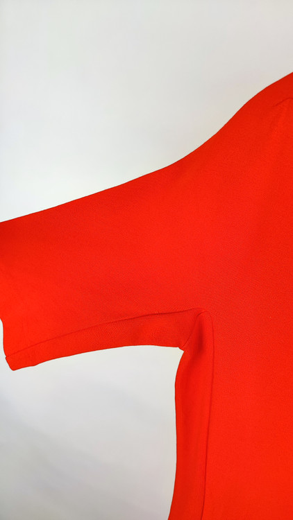 پیراهن زنانه استوک قرمز، آستین کوتاه با یقه باز، فرم ساده و جذب، قد میدی بلند، مناسب استایل رسمی و نیمهمجلس، ایستاده روی مدل با پسزمینه روشن.