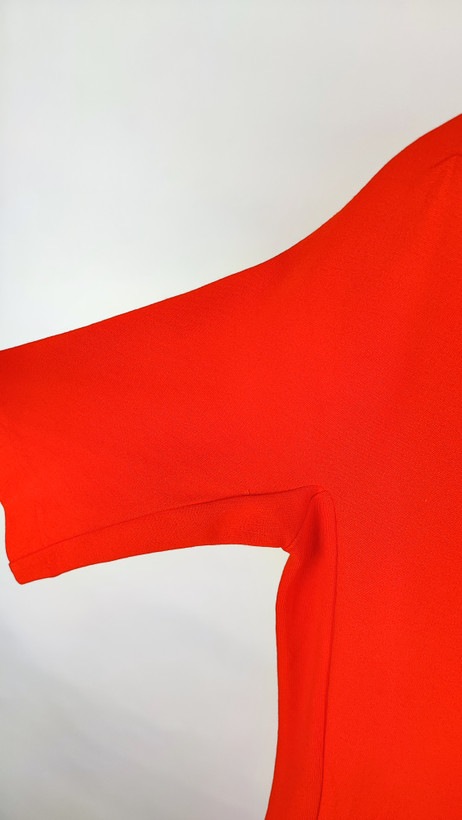 پیراهن زنانه استوک قرمز، آستین کوتاه با یقه باز، فرم ساده و جذب، قد میدی بلند، مناسب استایل رسمی و نیمهمجلس، ایستاده روی مدل با پسزمینه روشن.