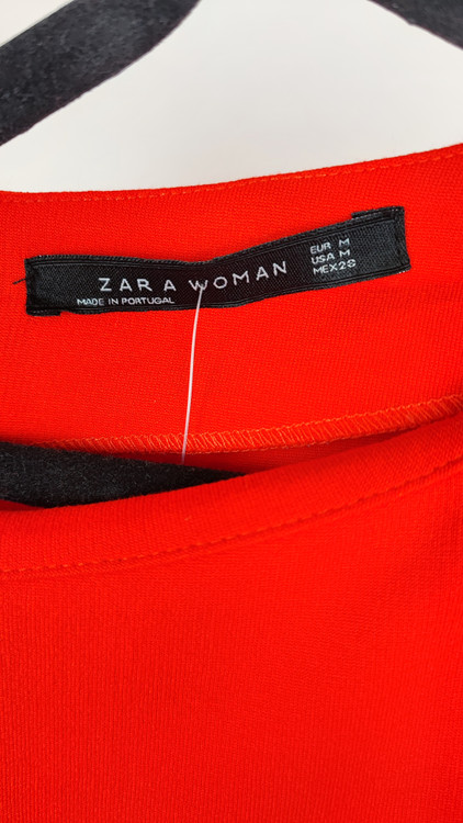 پیراهن زنانه استوک قرمز، آستین کوتاه با یقه باز، فرم ساده و جذب، قد میدی بلند، مناسب استایل رسمی و نیمهمجلس، ایستاده روی مدل با پسزمینه روشن.