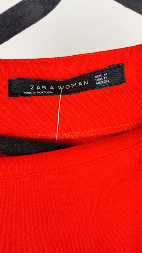 پیراهن زنانه استوک قرمز، آستین کوتاه با یقه باز، فرم ساده و جذب، قد میدی بلند، مناسب استایل رسمی و نیمهمجلس، ایستاده روی مدل با پسزمینه روشن.