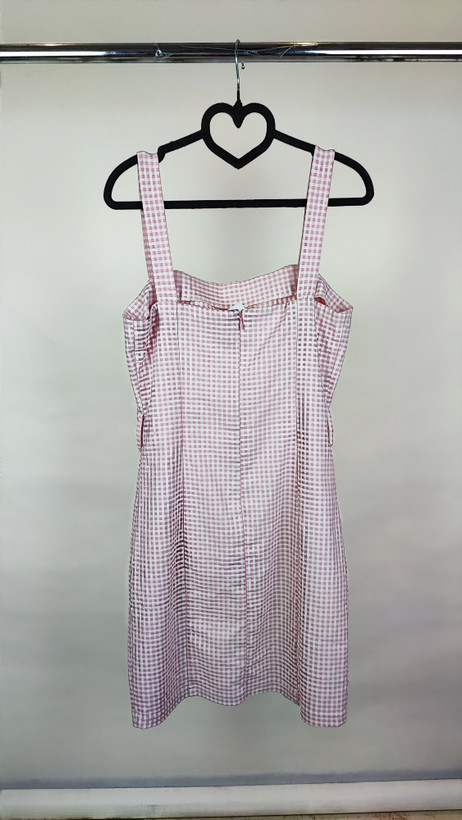 پیراهن زنانه استوک سفید/آفوایت، بدون آستین با یقه صاف و بند ظریف، فرم ساده و مینیمال، قد زیر زانو، تنخور مرتب و شیک، ایستاده روی مدل با پسزمینه روشن.