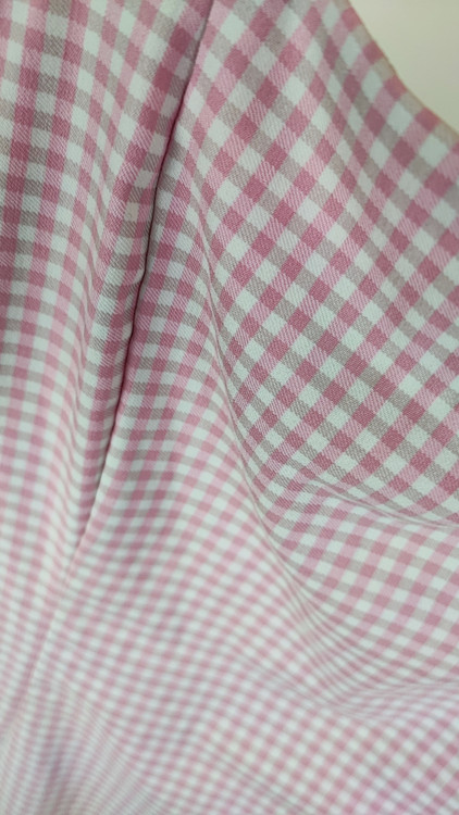 پیراهن زنانه استوک سفید/آفوایت، بدون آستین با یقه صاف و بند ظریف، فرم ساده و مینیمال، قد زیر زانو، تنخور مرتب و شیک، ایستاده روی مدل با پسزمینه روشن.