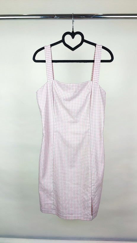 پیراهن زنانه استوک سفید/آفوایت، بدون آستین با یقه صاف و بند ظریف، فرم ساده و مینیمال، قد زیر زانو، تنخور مرتب و شیک، ایستاده روی مدل با پسزمینه روشن.