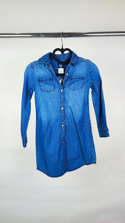 شومیز زنانه جین استوک آبی، آستین سهربع با یقه کلاسیک، قد متوسط و فرم ظریف، تنخور مرتب و جذب، ایستاده روی مدل با پسزمینه روشن.