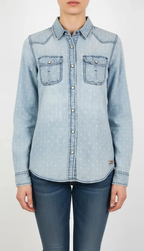 شومیز زنانه جین استوک رنگ آبی روشن، آستین بلند با فرم جذب و یقه کلاسیک، قد کوتاه و تنخور مرتب، ایستاده روی مدل با پسزمینه روشن.