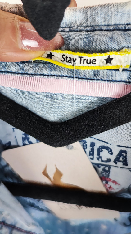 شومیز زنانه جین استوک رنگ آبی روشن، آستین بلند با فرم جذب و یقه کلاسیک، قد کوتاه و تنخور مرتب، ایستاده روی مدل با پسزمینه روشن.