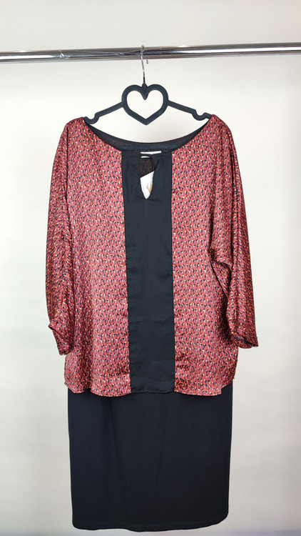 پیراهن زنانه استوک دو رنگ با ترکیب سرمهای و آجری، آستین سهربع و فرم آزاد، قد زیر زانو، ایستاده روی مدل با پسزمینه روشن.