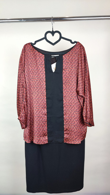 پیراهن زنانه استوک دو رنگ با ترکیب سرمهای و آجری، آستین سهربع و فرم آزاد، قد زیر زانو، ایستاده روی مدل با پسزمینه روشن.