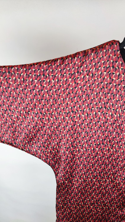 پیراهن زنانه استوک دو رنگ با ترکیب سرمهای و آجری، آستین سهربع و فرم آزاد، قد زیر زانو، ایستاده روی مدل با پسزمینه روشن.