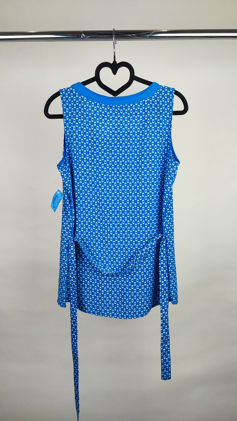 تاپ زنانه استوک وارداتی آبی با یقه هفت، بدون آستین، فرم ساده و جذب، مناسب استایل روزمره، روی تن مدل با پسزمینه روشن.