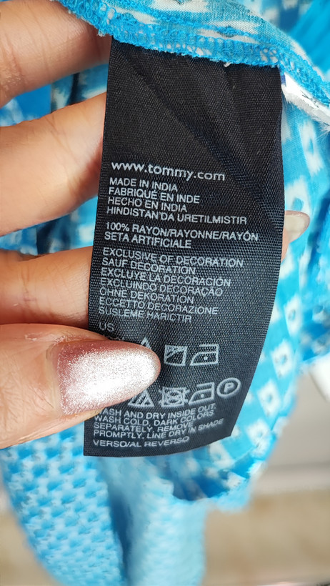 تاپ زنانه استوک وارداتی آبی با یقه هفت، بدون آستین، فرم ساده و جذب، مناسب استایل روزمره، روی تن مدل با پسزمینه روشن.