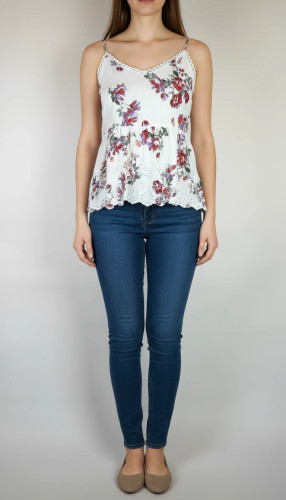 تاپ زنانه وارداتی استوک طرحدار، بدون آستین، یقه گرد، فرم ساده و خوشتن، مناسب استایل روزمره و تابستانی، روی تن مدل با شلوار جین و پسزمینه روشن.