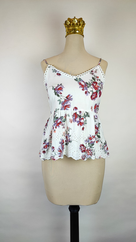 تاپ زنانه وارداتی استوک طرحدار، بدون آستین، یقه گرد، فرم ساده و خوشتن، مناسب استایل روزمره و تابستانی، روی تن مدل با شلوار جین و پسزمینه روشن.