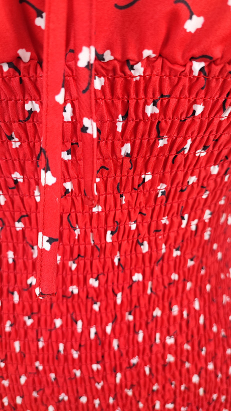 پیراهن زنانه وارداتی استوک قرمز، بنددار، یقه گرد باز، فرم نیمهچسبان تا بالای زانو، عرض سینه ۴۶ و قد ۸۷ سانتیمتر، مناسب استایل مهمانی و رسمی، عکاسی شده روی تن با پسزمینه ساده روشن.