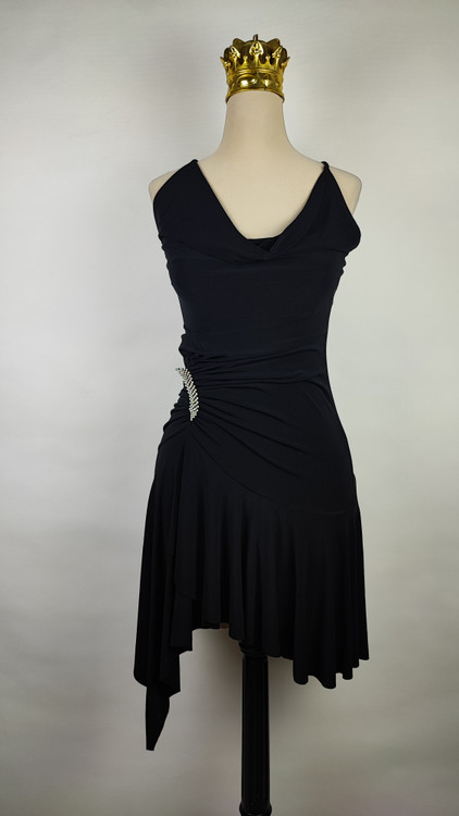 پیراهن زنانه وارداتی استوک مشکی بنددار، یقه هفت، فرم آزاد با پاییندوزی نامتقارن، قد حدود ۹۵ سانتیمتر، مناسب استایل مهمانی و شب، عکاسیشده روی تن با پسزمینه ساده روشن.