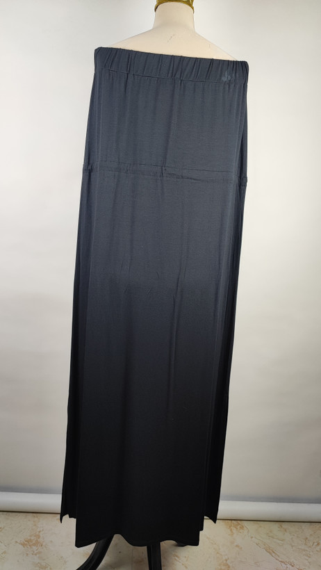 پیراهن زنانه وارداتی استوک مشکی بلند، دکلته بدون بند، فرم آزاد تا کف، عرض سینه ۵۵ و قد ۱۲۵ سانتیمتر، مناسب استایل رسمی و شب، عکاسیشده روی تن با بکگراند روشن ساده.