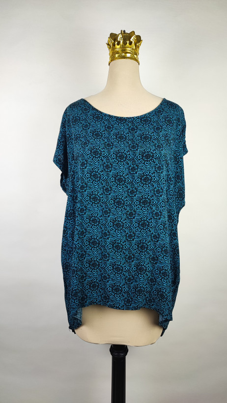 شومیز زنانه وارداتی استوک طرحدار آبی، آستین کوتاه، فرم آزاد، مناسب سایز ۴۸ تا ۵۰، عرض سینه ۶۲ و قد ۶۷ سانتیمتر، مناسب استفاده روزمره، عکاسیشده روی تن با پسزمینه روشن ساده.