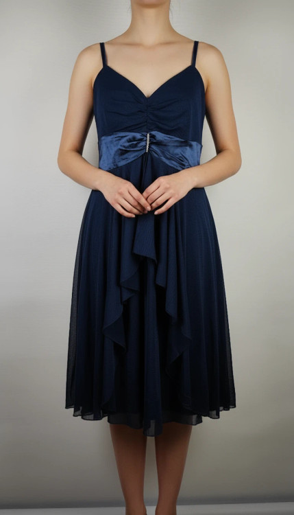 پیراهن زنانه استوک مشکی بنددار، یقه ضربدری، قد ۱۱۰ سانتیمتر، فرم آزاد و شیک، مناسب سایز ۴۲ تا ۴۴، مناسب مهمانی و استایل شب، عکاسیشده روی تن با پسزمینه روشن.