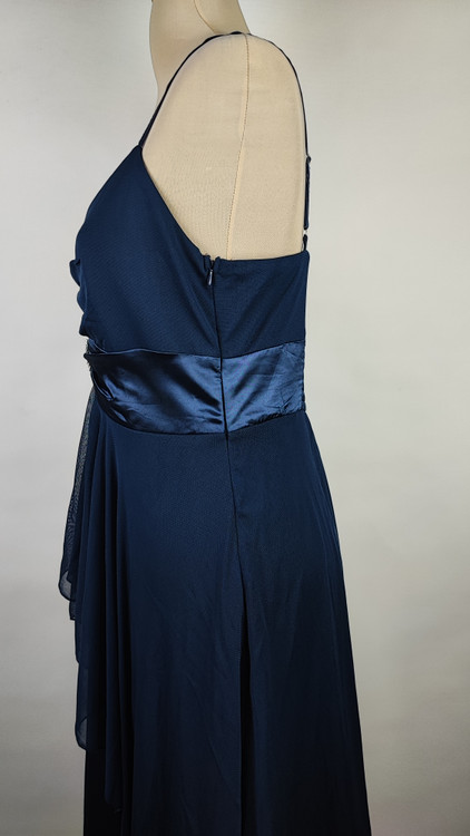 پیراهن زنانه استوک مشکی بنددار، یقه ضربدری، قد ۱۱۰ سانتیمتر، فرم آزاد و شیک، مناسب سایز ۴۲ تا ۴۴، مناسب مهمانی و استایل شب، عکاسیشده روی تن با پسزمینه روشن.