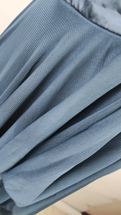 پیراهن زنانه استوک مشکی بنددار، یقه ضربدری، قد ۱۱۰ سانتیمتر، فرم آزاد و شیک، مناسب سایز ۴۲ تا ۴۴، مناسب مهمانی و استایل شب، عکاسیشده روی تن با پسزمینه روشن.