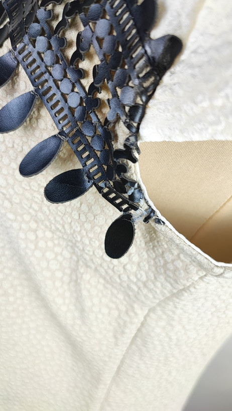 پیراهن زنانه وارداتی استوک، رنگ کرم با نوار چرم مشکی در یقه، مدل راسته، قد ۹۷ و عرض سینه ۵۰ سانتیمتر، مناسب سایز ۴۰ تا ۴۲، ایراد در قسمت چرم، عکاسی روی تن با بکگراند روشن