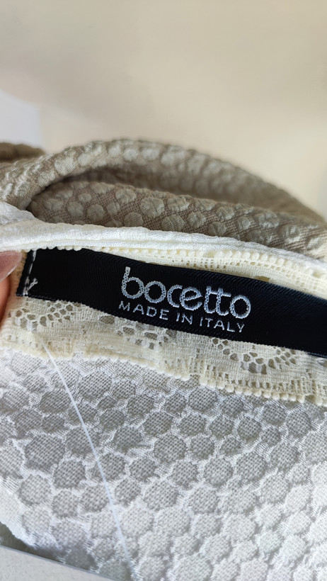 پیراهن زنانه وارداتی استوک، رنگ کرم با نوار چرم مشکی در یقه، مدل راسته، قد ۹۷ و عرض سینه ۵۰ سانتیمتر، مناسب سایز ۴۰ تا ۴۲، ایراد در قسمت چرم، عکاسی روی تن با بکگراند روشن