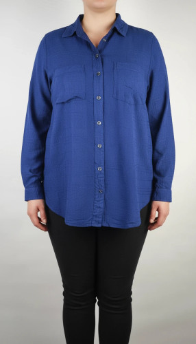 شومیز زنانه وارداتی استوک به رنگ آبی، مدل ساده و آزاد با یقه هفت و آستین بلند، مناسب سایز ۴۲–۴۴، عرض سینه ۵۵ و قد ۷۴ سانتیمتر، دارای ایراد، عکاسی روی تن با شلوار مشکی و پسزمینه روشن.