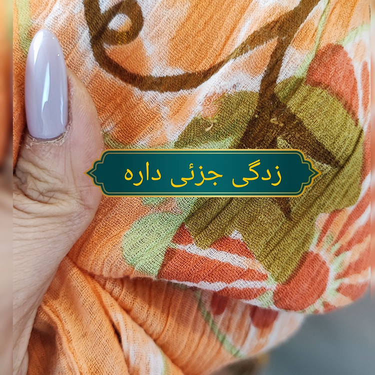 شومیز زنانه طرحدار نارنجی وارداتی با قواره آزاد کد ۱ * تصویر جزئیات: نمای نزدیک از زدگیهای جزئی در بافت پارچه شومیز استوک کد