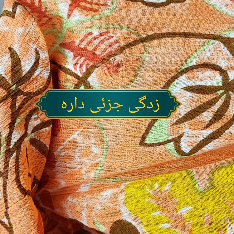 شومیز زنانه طرحدار نارنجی وارداتی با قواره آزاد کد ۱ * تصویر جزئیات: نمای نزدیک از زدگیهای جزئی در بافت پارچه شومیز استوک کد