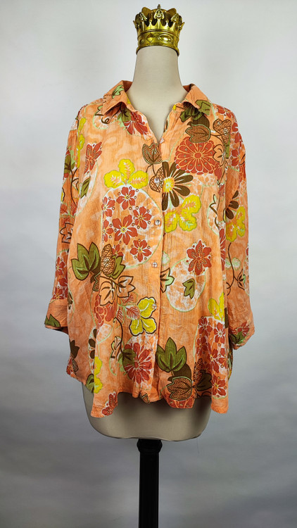 شومیز زنانه طرحدار نارنجی وارداتی با قواره آزاد کد ۱ * تصویر جزئیات: نمای نزدیک از زدگیهای جزئی در بافت پارچه شومیز استوک کد