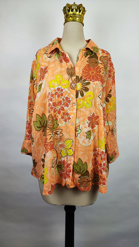 شومیز زنانه طرحدار نارنجی وارداتی با قواره آزاد کد ۱ * تصویر جزئیات: نمای نزدیک از زدگیهای جزئی در بافت پارچه شومیز استوک کد