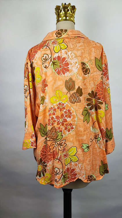 شومیز زنانه طرحدار نارنجی وارداتی با قواره آزاد کد ۱ * تصویر جزئیات: نمای نزدیک از زدگیهای جزئی در بافت پارچه شومیز استوک کد