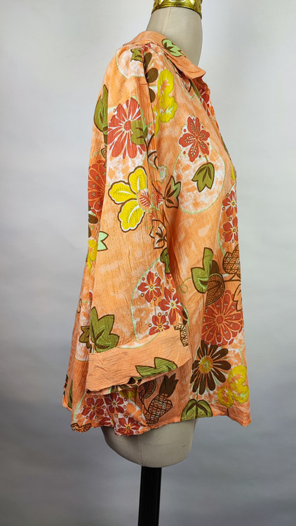 شومیز زنانه طرحدار نارنجی وارداتی با قواره آزاد کد ۱ * تصویر جزئیات: نمای نزدیک از زدگیهای جزئی در بافت پارچه شومیز استوک کد